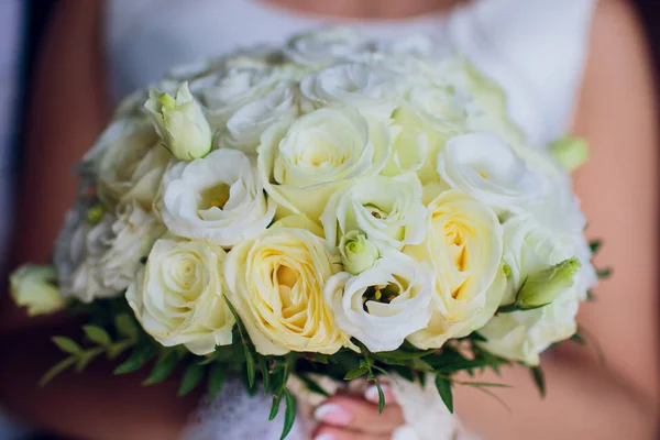 De bruid houdt een boeket van de bruid van witte rozen en eustoma. — Stockfoto