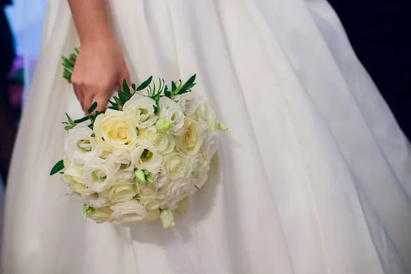 De bruid houdt een boeket van de bruid van witte rozen en eustoma. — Stockfoto