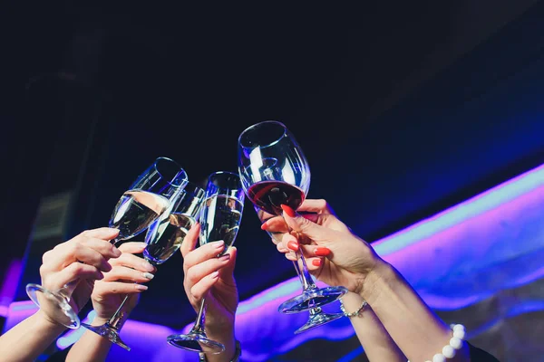 Rammelende glazen rode wijn in handen op felle lichten achtergrond. — Stockfoto