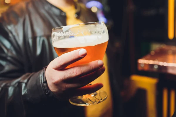 Un homme tient une bière dans sa main . — Photo