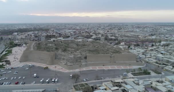 Aérienne La haute tour de la forteresse Kunya-Ark, entourée de remparts de Itchan Kala - la fortification médiévale de Khiva, Ouzbékistan . — Video