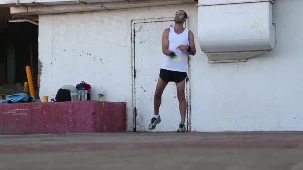 04.9.2018: Der Mann knetet auf dem Sportplatz vor dem Wettkampf mit dem Partner im Squash-Spiel. Unternehmenssport. Handyspiel mit Schläger und Ball. — Stockvideo