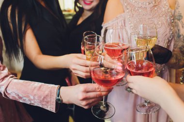 Partide insanların elinde şampanya bardakları.