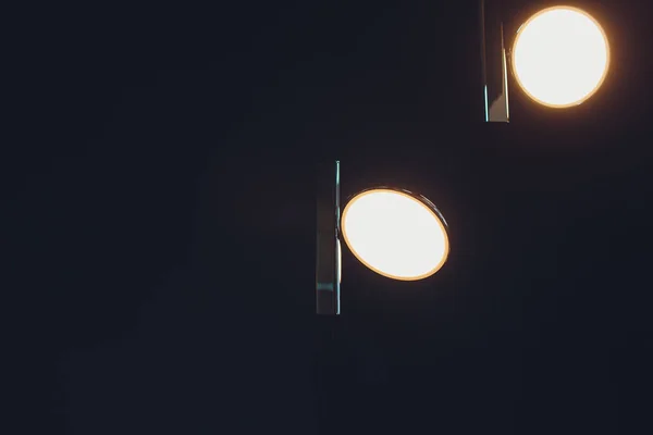 Duas lâmpadas incadescentes numa lâmpada industrial. Ambiente escuro. Conceito de ideia. Copiar espaço à esquerda . — Fotografia de Stock
