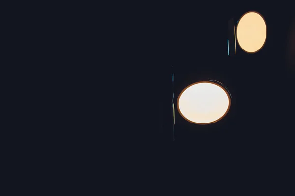 Två glödlampor i en industrilampa. Mörk miljö. Begreppet idé. Kopiera utrymme till vänster. — Stockfoto