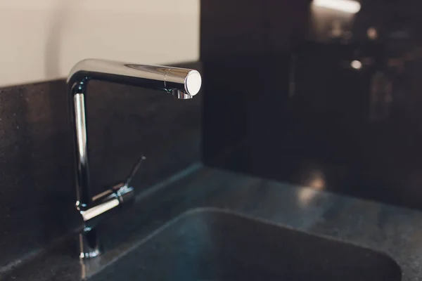 Modern kitchen sink with metal tap and black marble. — Stock Photo, Image