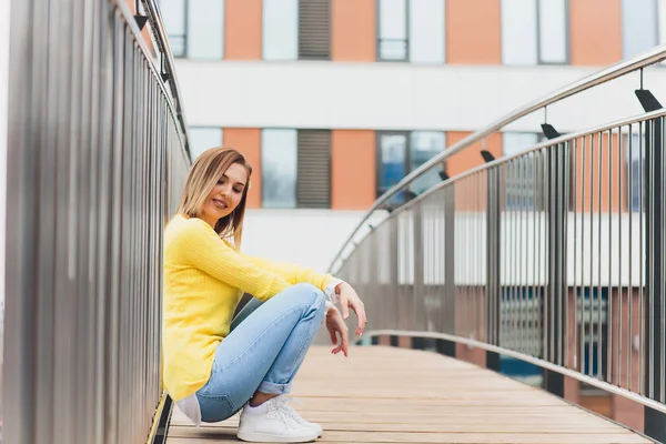 노란색 스웨터와 청바지에 아름다운 매력적인 여자는 도시 산책. — 스톡 사진