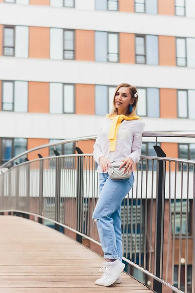 Хіпстерська дівчина в порожній білій футболці і джинсах позує на дорогу, мінімалістичний стиль міського одягу . — стокове фото