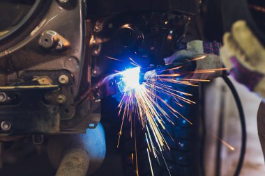 Otomotiv endüstrisinde profesyonel tamirci metal gövde arabalarını kıvılcımlarla dolduruyor..