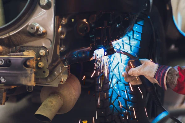 Επαγγελματίας επισκευαστής αυτοκινήτων βιομηχανία συγκόλλησης μετάλλων αμαξώματος αυτοκινήτων με σπινθήρες. — Φωτογραφία Αρχείου