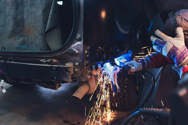Επαγγελματίας επισκευαστής αυτοκινήτων βιομηχανία συγκόλλησης μετάλλων αμαξώματος αυτοκινήτων με σπινθήρες. — Φωτογραφία Αρχείου