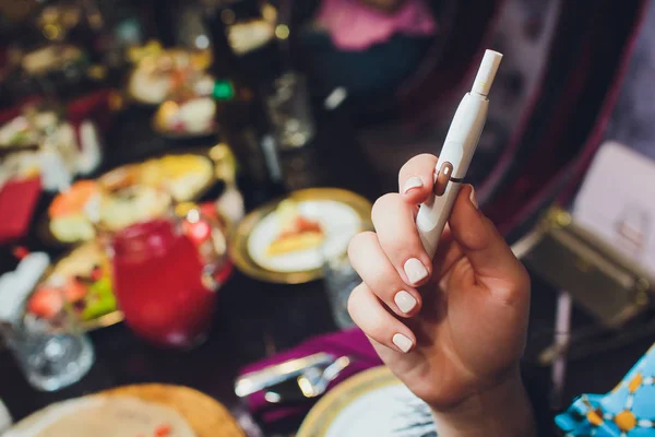 Tecnología de productos de tabaco sin combustión por calor. Mujer sosteniendo el cigarrillo electrónico en su mano antes de fumar. — Foto de Stock