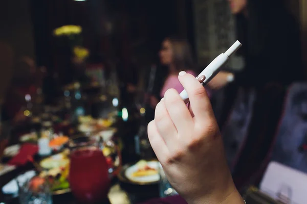 熱を出さないタバコ製品技術。喫煙する前に手に電子タバコを持っている女性. — ストック写真