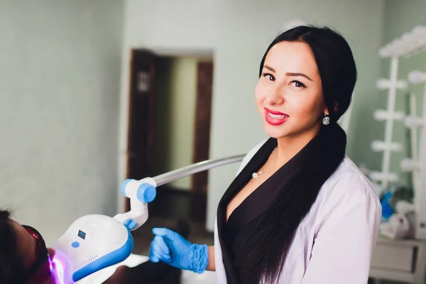 Zahnarzt erklärt dem Patienten in der Zahnklinik das Implantat der Zähne. — Stockfoto