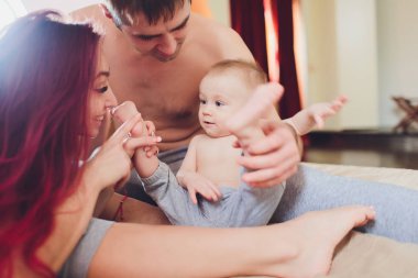 Sevimli küçük kız bebek ile mutlu anne evde kanepede oturan, ebeveynlik zevk, genç mutlu aile, yeni bir yaşam kavramı.