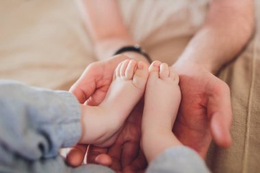 bebeğin bacakları holding ebeveyn eller.