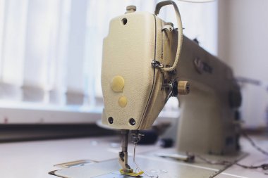 Arka planda atelier Studio profesyonel dikiş makinesi. İşyeri terzi - Dikiş Makinası, iplik, kumaş, makas alır. Dikiş iş kavramı.