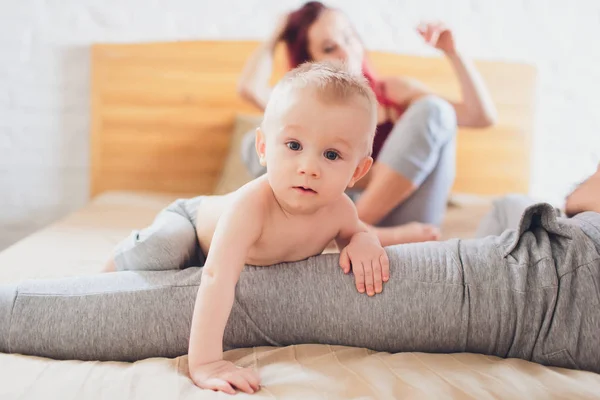 Padres felices con adorable niñita sentada en el sofá en casa, disfrutando de la paternidad, familia feliz joven, nuevo concepto de vida . —  Fotos de Stock