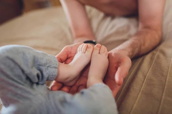 Ouderlijke handen met benen van de baby. — Stockfoto