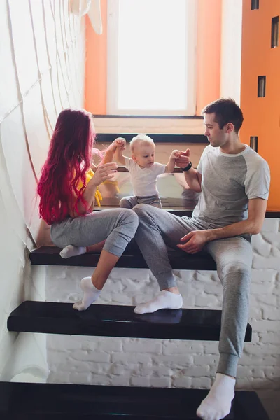 El padre, la madre y los hijos sentados en las escaleras . —  Fotos de Stock