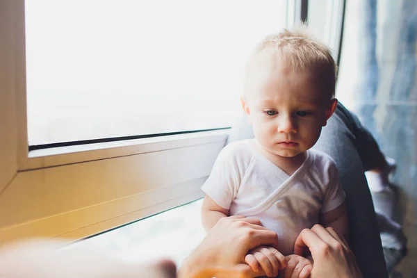 Madre cariñosa jugando con su bebé sentado en una ventana . —  Fotos de Stock