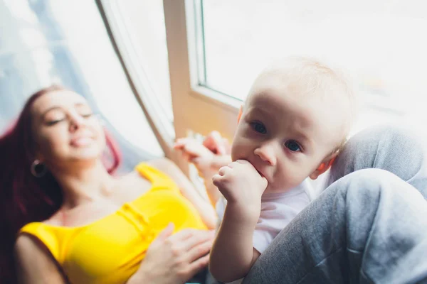사랑의 어머니는 창에 앉아 그녀의 아기와 함께 재생. — 스톡 사진