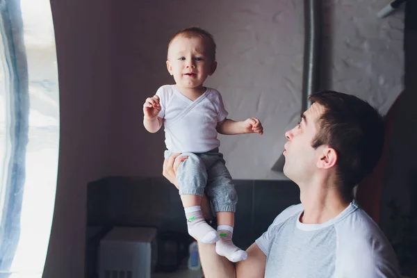 Young happy father holding baby son in hands over his head. — 스톡 사진