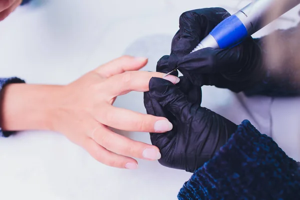 Hands in gloves cares about mans hand nails. Manicure beauty salon. — Stock Photo, Image