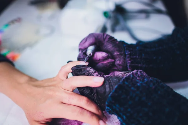 Händerna i handskar bryr sig om mans hand naglar. Manikyr skönhetssalong. — Stockfoto