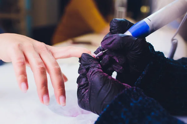 Hands in gloves cares about mans hand nails. Manicure beauty salon. — Stock Photo, Image