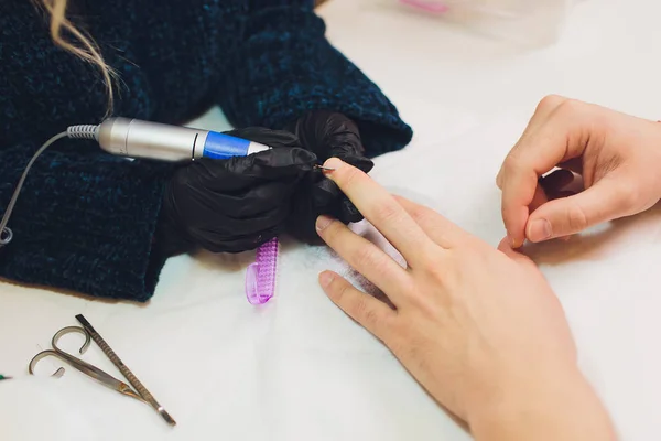 Hands in gloves cares about mans hand nails. Manicure beauty salon. — Stock Photo, Image