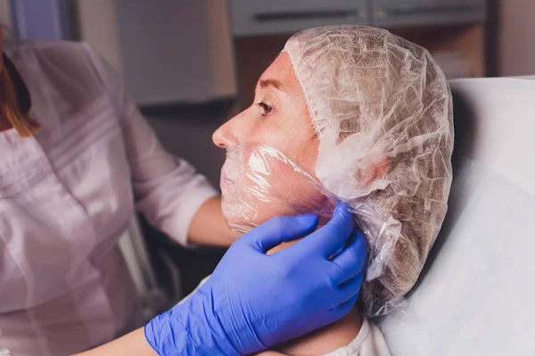 De arts schoonheidsspecialist maakt gezicht injecties procedure voor het aanscherpen en glad rimpels op het gezicht huid van een mooie, jonge vrouw in een schoonheidssalon. Cosmetische huidverzorging. — Stockfoto