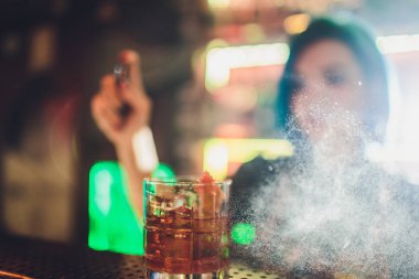 Kadın barmen çelik üzerinde hizmet için taze lezzetli kokteyl püskürtme bar counter.
