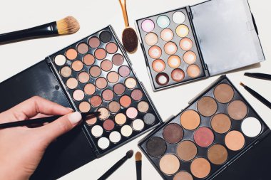 Makyaj fırçaları ve makyaj göz farları beyaz bir arka plan üzerinde.