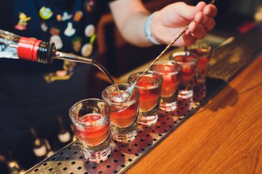 Barmen adam profesyonel bir yazıcı ile pub bar sıcak alkol çekim yapma. Barmen, bir bardak daha hafif ışıklar. Gece kulübünde rahatlayın. Sıcak ateş içer. Parti sağlar.