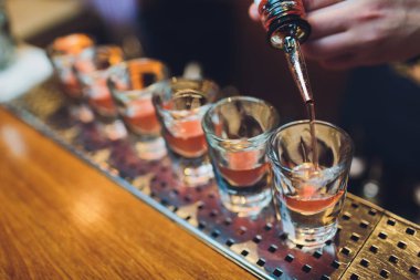 Barmen adam profesyonel bir yazıcı ile pub bar sıcak alkol çekim yapma. Barmen, bir bardak daha hafif ışıklar. Gece kulübünde rahatlayın. Sıcak ateş içer. Parti sağlar.