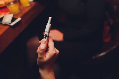 Iqos ısı-değil-yanık tütün ürün teknolojisi. E-Sigara İçilmeyen önce elinde tutan kadın.