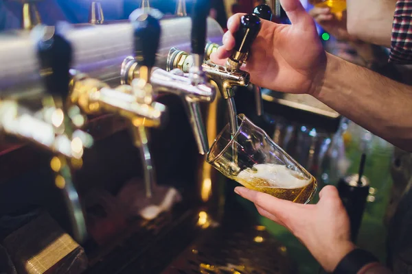 Крупним планом рука бармена під пивним краном, що поливає пиво з осадкою . — стокове фото