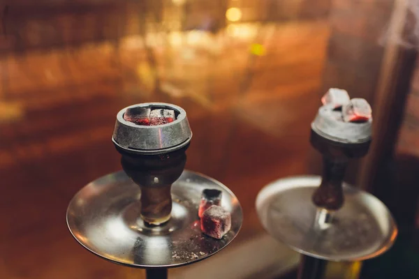 Heiße rote Kohlen für Shisha, die auf dem Herd in einer Shisha-Bar vor dunklem Hintergrund aufgewärmt werden. — Stockfoto