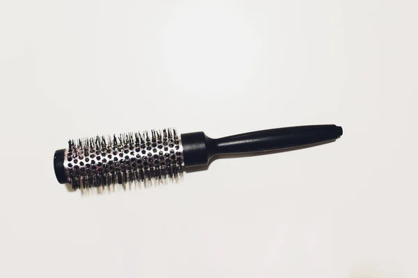 Escova de cabelo redonda com uma maçaneta em um fundo branco . — Fotografia de Stock