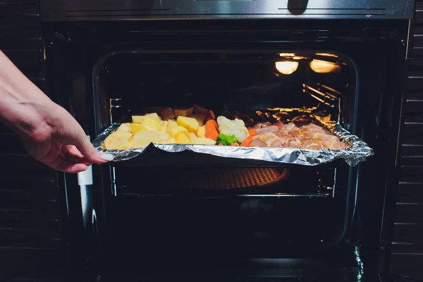 Cozinhe tomando frango assado frito pronto com legumes do forno. Conceito de cozinha doméstica . — Fotografia de Stock