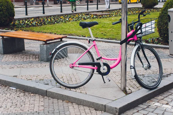 Женщина розовый велосипед с плетеной корзиной на старой улице . — стоковое фото
