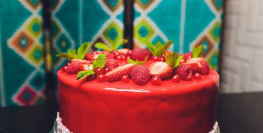 Taze çilek, ahududu, yaban mersini, kuş üzümü ve ahşap zemin üzerine Antep fıstığı ile lezzetli frambuazlı pasta.