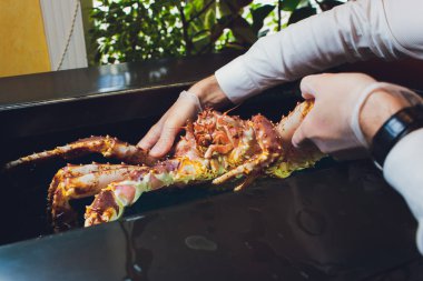 Beyaz üniformalı şef aşçı restoran taze büyük kamçatka yengeç tutuyor. Kavram sağlıklı gıda, yaşam tarzı, yararlı deniz ürünleri, incelik, diyet, elit beş yıldızlı otel menüsünde.