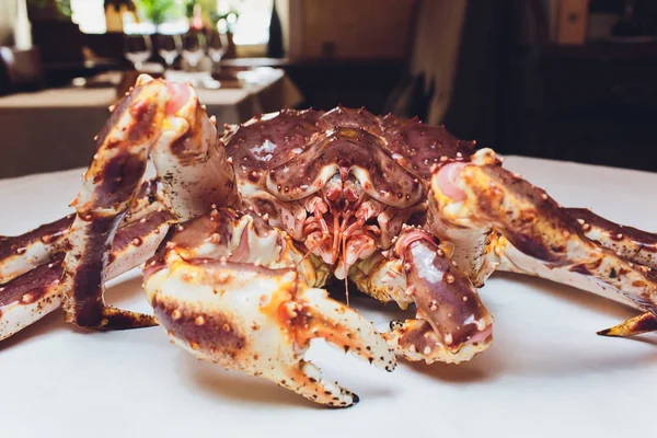 Cangrejo Rey vivo sobre fondo blanco sucinto. tumbado sobre la mesa sobre el fondo del restaurante — Foto de Stock