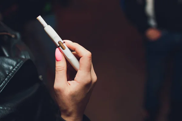 Tecnologia dei prodotti del tabacco non bruciati termicamente. Donna che tiene la sigaretta elettronica in mano prima di fumare. — Foto Stock