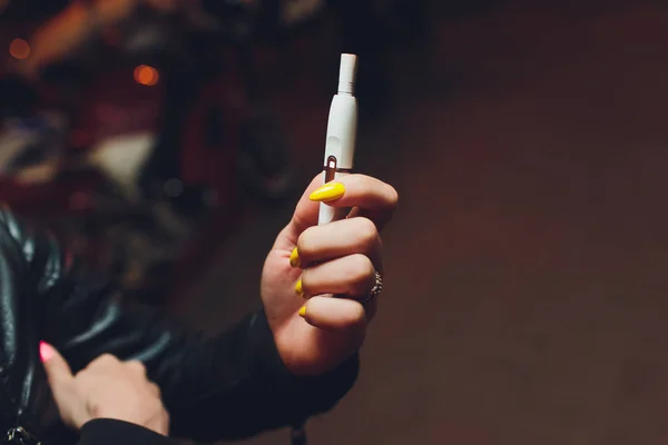 Технологія виробництва тютюнових виробів, що не спалюються. Жінка тримає електронну сигарету в руці перед курінням . — стокове фото