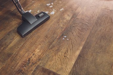 Halıyı süpürerken kullanılan modern bir elektrikli süpürgenin karanlık kafası. Temizlik hizmeti konsepti. Elektrikli süpürge ile proses halı.