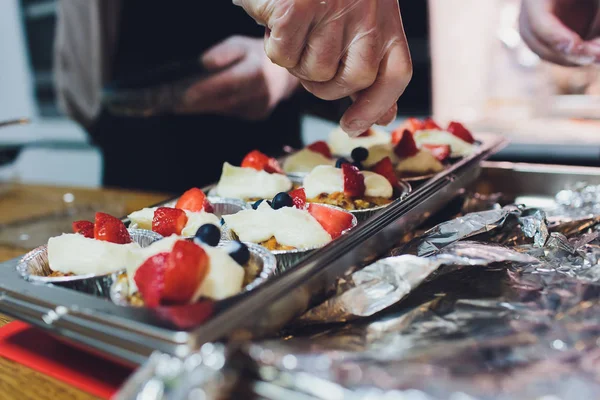 Een chef-kok decoreert vele platen van cake. — Stockfoto