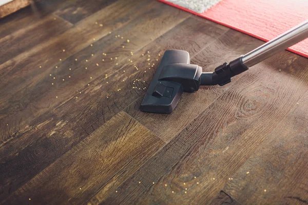 Dark head of a modern vacuum cleaner being used while vacuuming a rug. Cleaning service concept. Process carpet with vacuum cleaner. — Stock Photo, Image